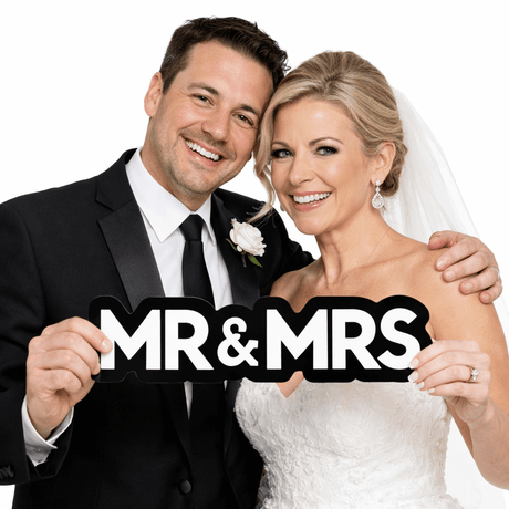 A happy couple holding the Mr&Mrs Individual Prop, showcasing a fun and memorable wedding moment.