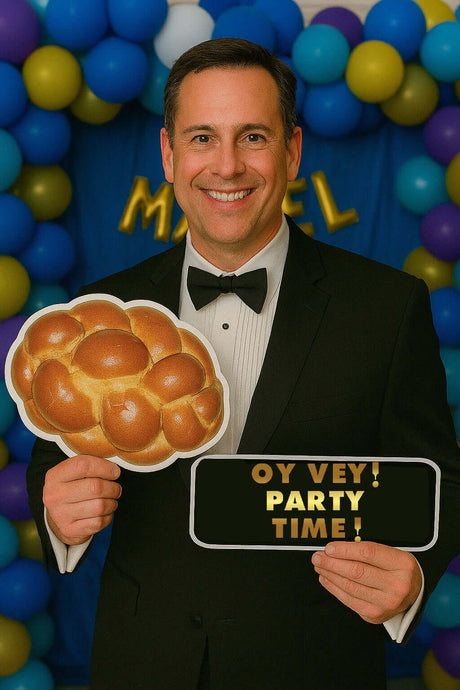 Man holding challah bread and party sign at a Mitzvah photo booth with colorful backdrop.