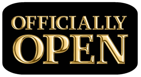 Sign that reads 'OFFICIALLY OPEN' in gold lettering on a black background for business openings.