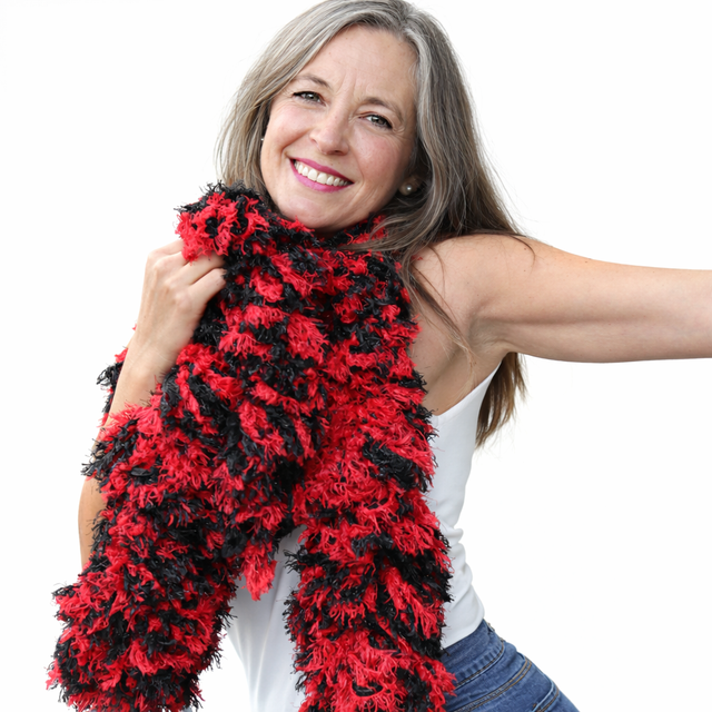 Super Sized RED AN BLACK Mixed Featherless Boa worn by a smiling woman, showcasing its vibrant colors and fun design.
